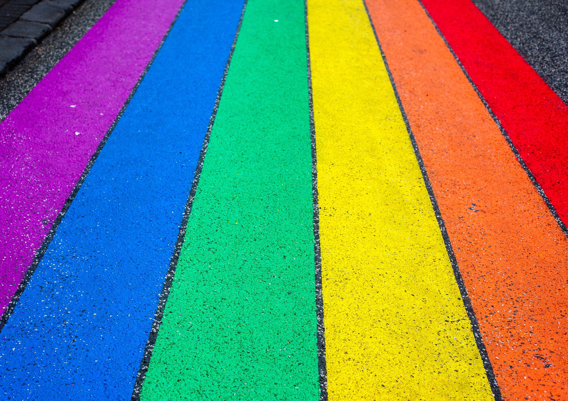 Rainbow painted on the road in support of the LGBTQ+ community. Even as an adult, navigating the mental ups and downs associated with the unique challenges faced by the LGBTQ+ community can be difficult. An LGBTQ+ affirming therapist can help you find peace and stability in your daily life.