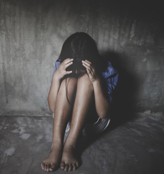 Woman sitting in a gray room with her hands on her head representing someone who is struggling in an abusive relationship. Group Therapy in Pasadena can help heal those wounds.